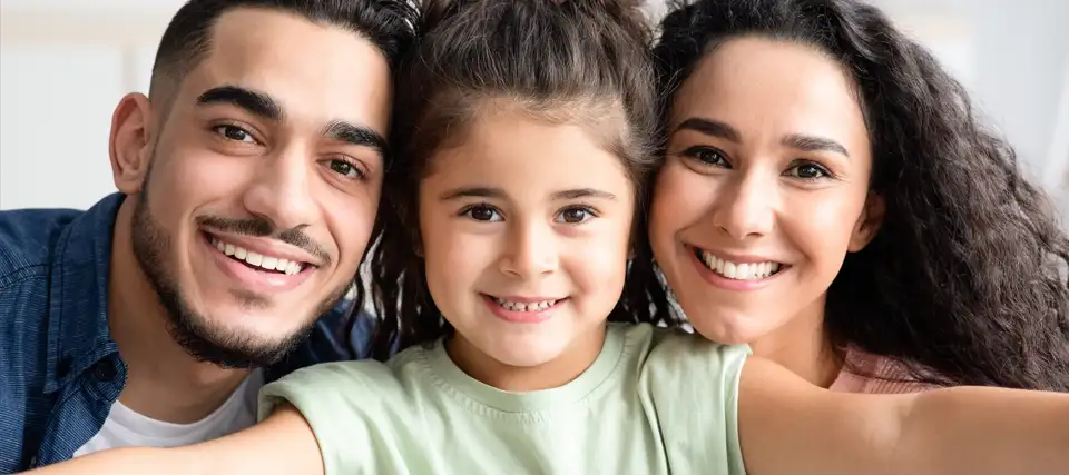 a happy smiling mother with her son and daughter looking up at the camera